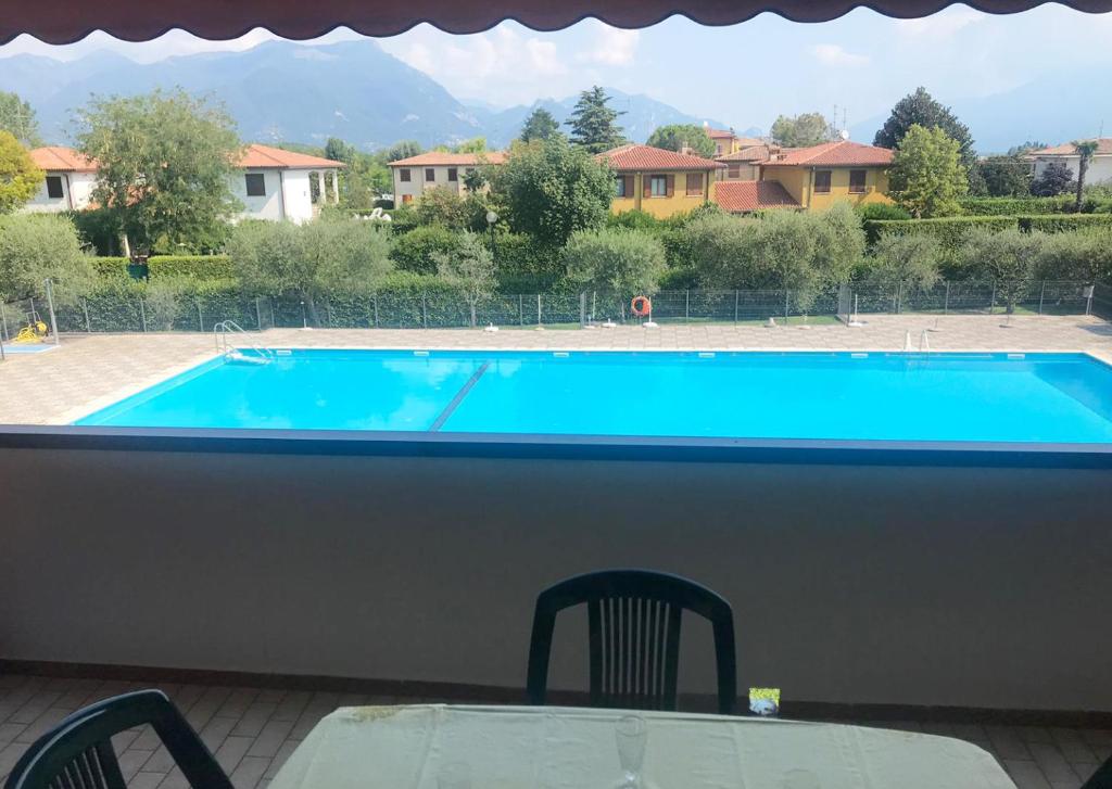 uitzicht op een zwembad met een tafel en stoelen bij La Maison du Port - Apartment with Pool in Manerba del Garda