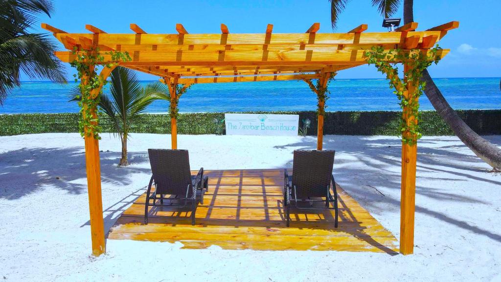 - deux chaises sous un kiosque sur la plage dans l'établissement The Zanzibar Beach House-North, à Pingwe
