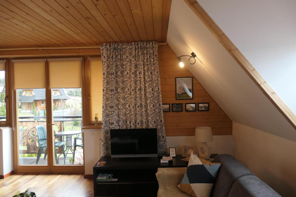 Televízia a/alebo spoločenská miestnosť v ubytovaní Apartament Panorama Tatry
