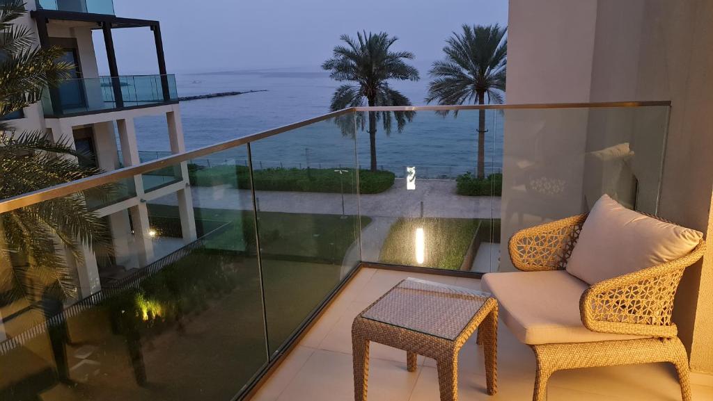 a balcony with a chair and a view of the ocean at The Address Beach Resort Fujairah in Sharm