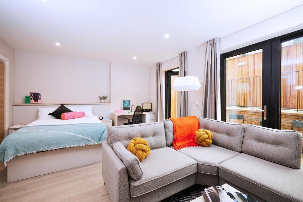1 dormitorio con sofá y cama en ALTIDO Aparthotel at Vita Iona Street - Adults only en Edimburgo