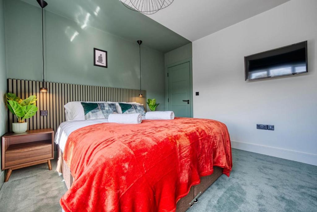 um quarto com uma cama grande e um cobertor vermelho em Stylish 3 Bedroom Apartment em Southampton