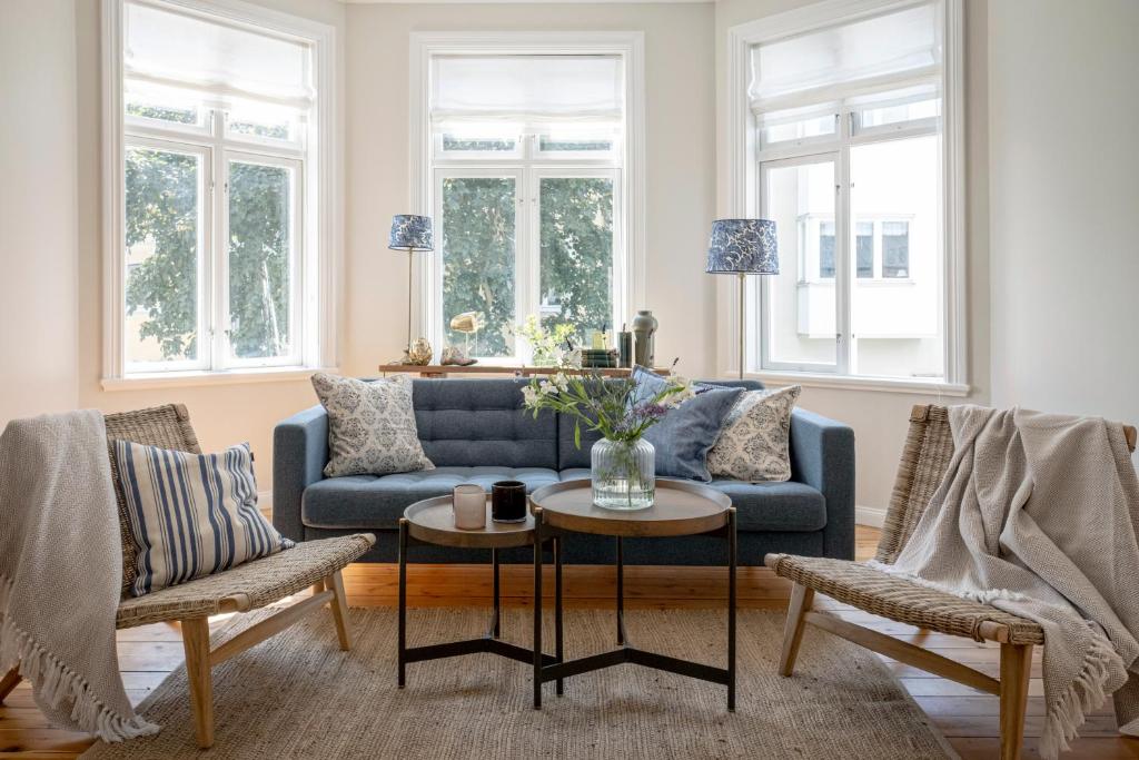 a living room with a blue couch and two chairs at Blå Huset in Vaxholm