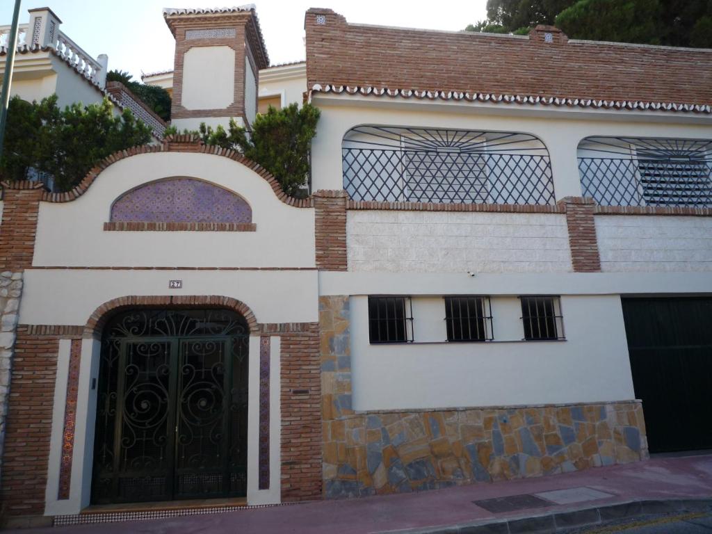 マラガにあるFlamencos del cerradoの黒い扉と門のある家