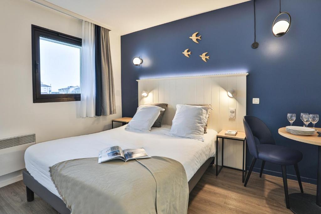 Habitación de hotel con cama y escritorio en Résidence Pierre & Vacances Centre en La Rochelle