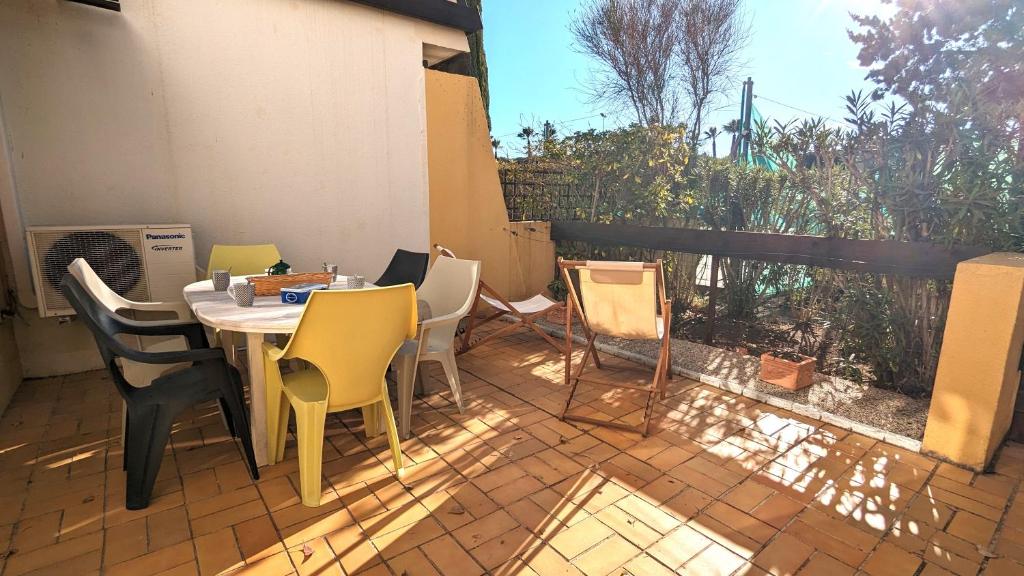 un patio avec une table, des chaises et une fenêtre dans l'établissement 5046 Tennis Village plus 1405, au Cap d'Agde