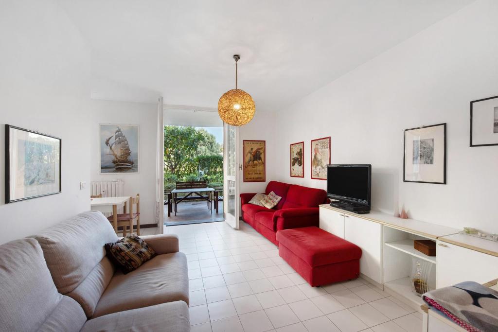 uma sala de estar com um sofá e uma cadeira vermelha em Casa Laura em Arenzano