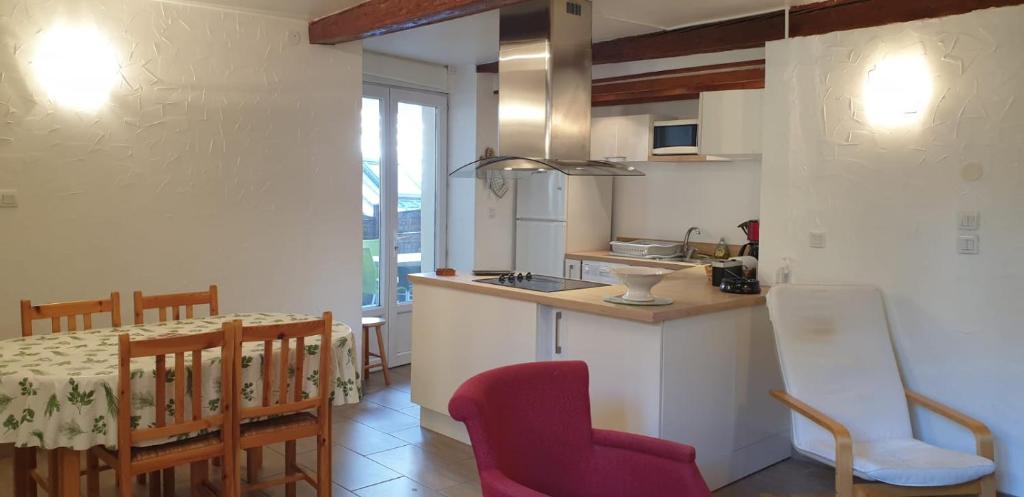 una cucina e una sala da pranzo con tavolo e sedie di Métropole a Embrun