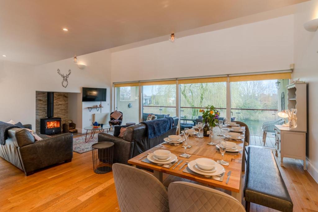 a dining room with a table and a living room at Firecrest in Somerford Keynes
