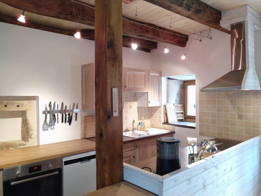 une cuisine avec un évier et une cuisinière four supérieur dans l'établissement Maison coeur de causse, à Fontanes-du-Causse