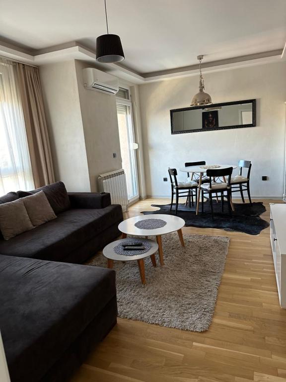 een woonkamer met een bank en een tafel bij Apartman DM in Zvezdara