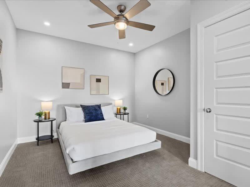 a white bedroom with a bed and a ceiling fan at CozySuites 1BR, PPG Paints Arena, Pitts in Pittsburgh