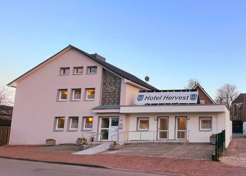 a white building with a sign on top of it at Hotel Hervest in Dorsten