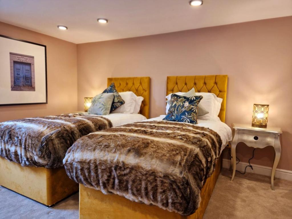 een slaapkamer met 2 bedden en een bijzettafel bij Hamilton-The Alexander suite luxury holiday let's in Scorton