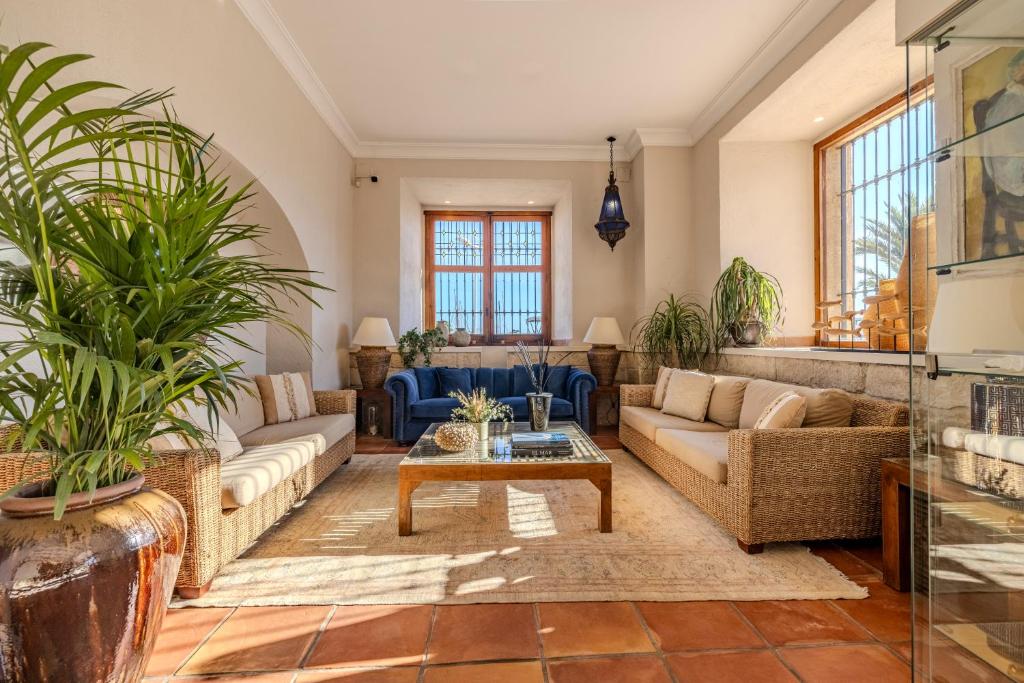 una sala de estar con sofás y macetas. en La Posada del Mar, en Denia