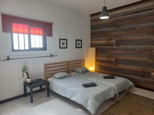 a bedroom with a bed and a wooden wall at Sunset house in Soo