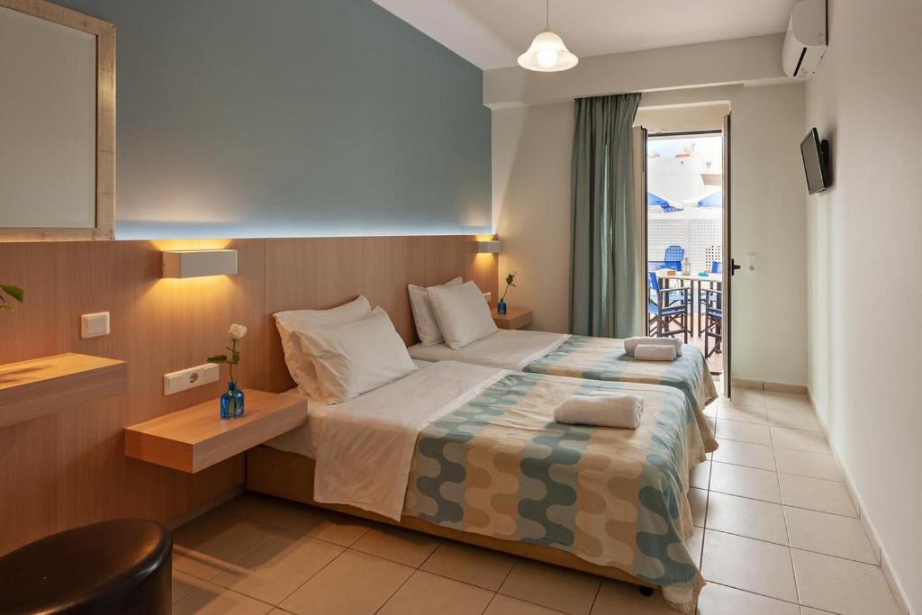 プラタネスにあるOliv Apartmentsの海の景色を望むベッド付きのホテルルームです。