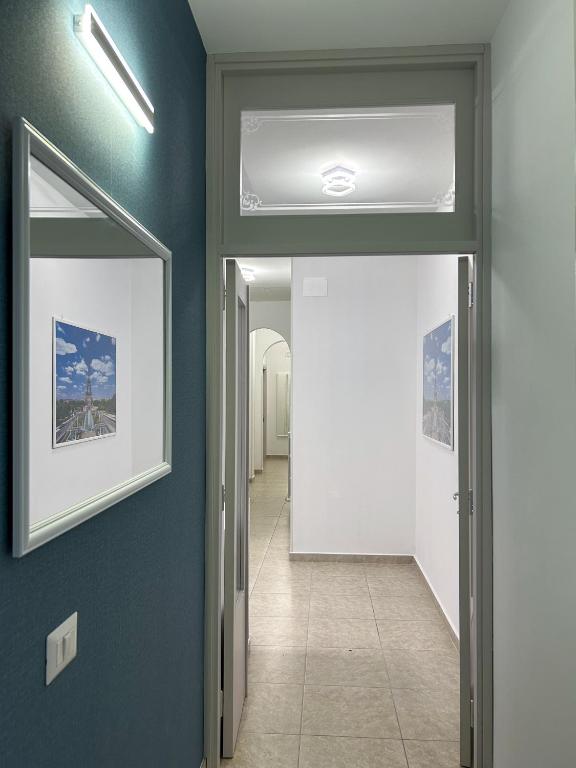 a hallway with blue walls and a ceiling with a mirror at Puzzle Rooms in Campobasso