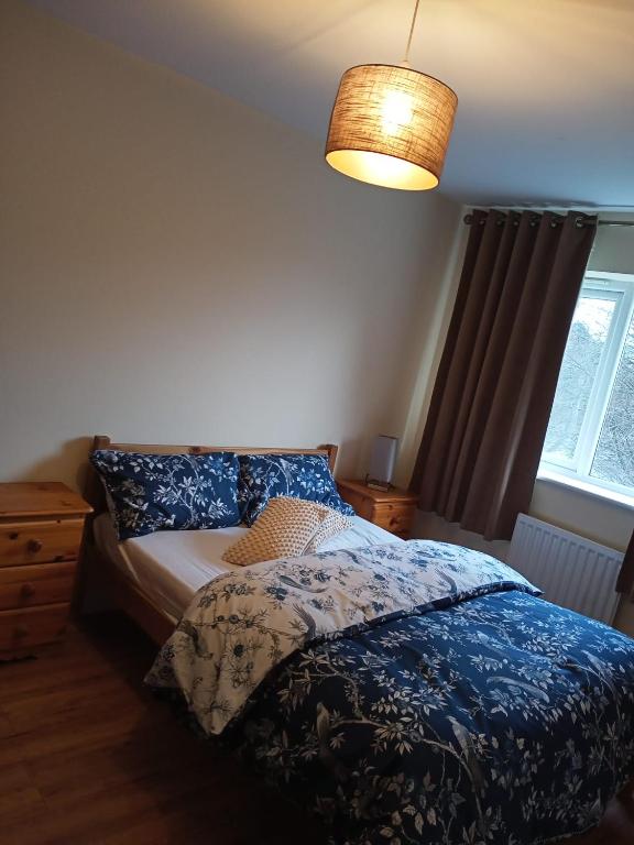 a bedroom with a bed and a lamp and a window at Highly Comfortable Home in Hatfield