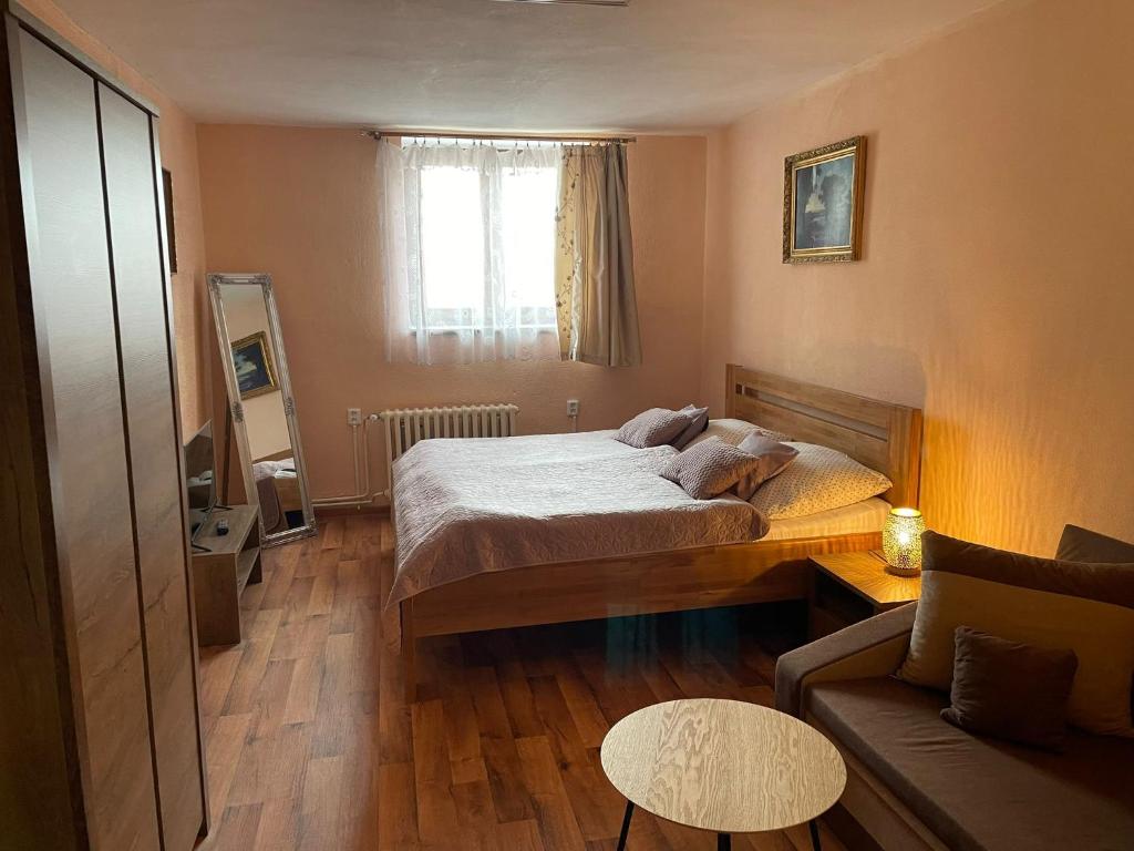 een kleine slaapkamer met een bed en een bank bij Hotel U Beránků in Libochovice