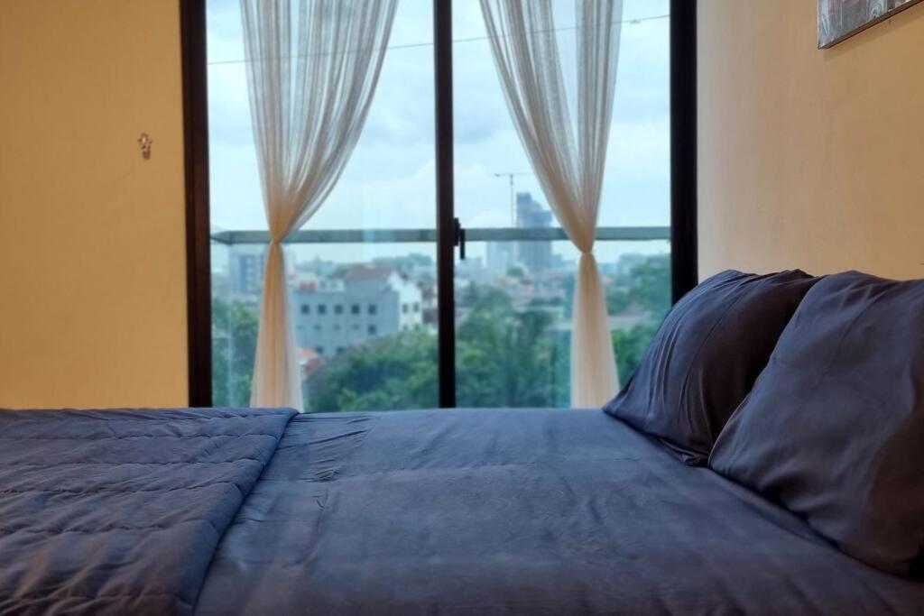 a bedroom with a bed with a large window at Apt Capitol Suite Senen 2 BR with Pool & Wifi in Jakarta