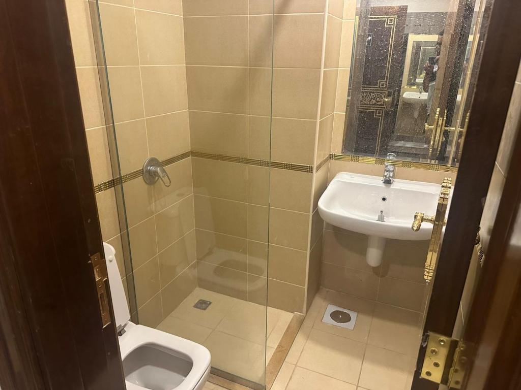 a bathroom with a shower and a sink and a toilet at مشارق مني in Al ‘Azīzīyah