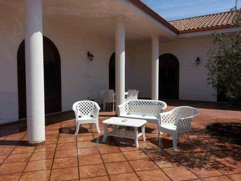 2 sillas y una mesa en el patio en Villa Silvia, en Alliste