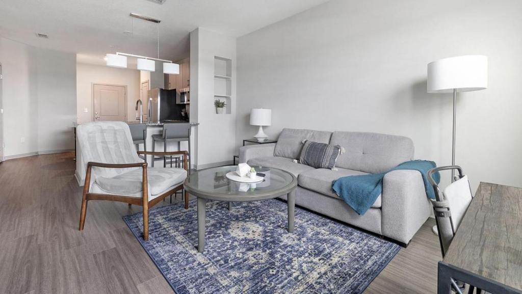 a living room with a couch and a table at Landing Modern Apartment with Amazing Amenities (ID1239X542) in Middleburg