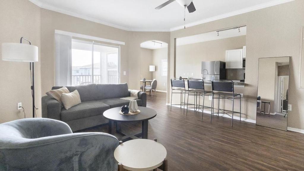 sala de estar con sofá y sillas y cocina en Landing Modern Apartment with Amazing Amenities (ID1403X079), en Pinellas Park