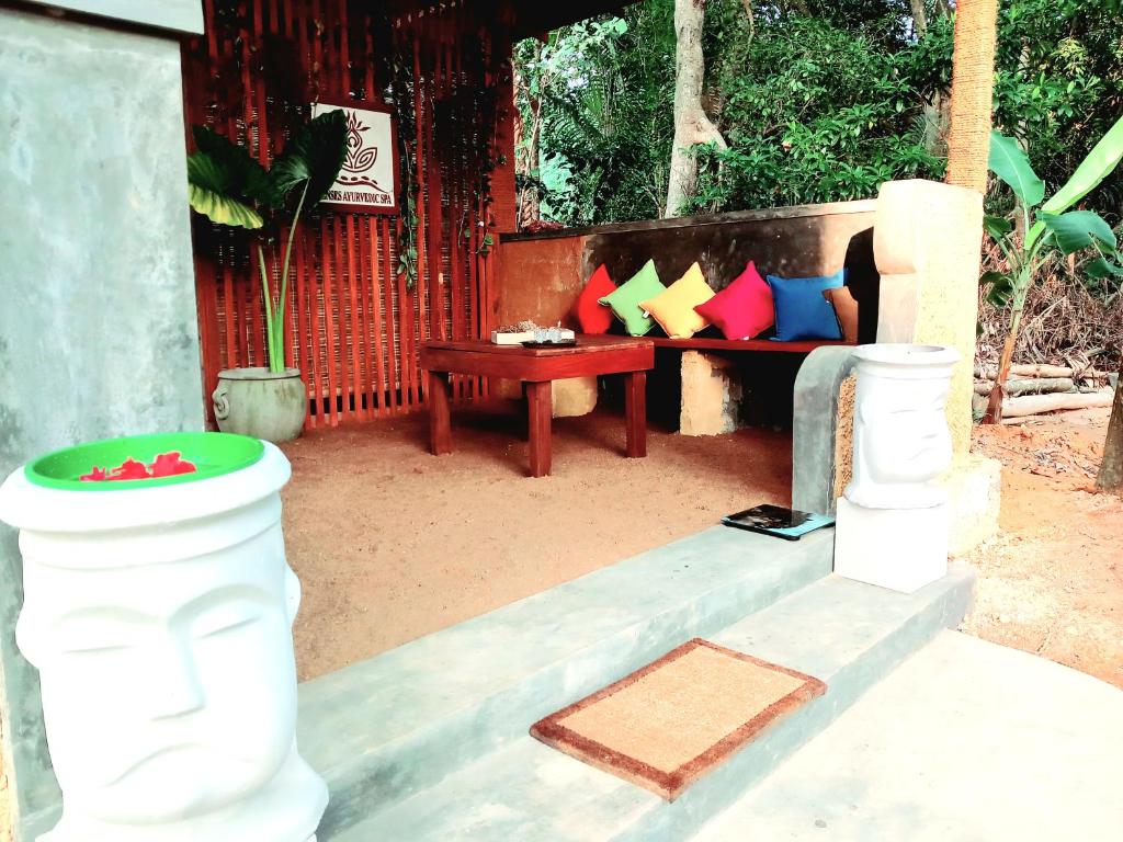 a porch with a bench with a table and a table at Selnara Private Luxury Villa and Ayurveda Spa in Bentota