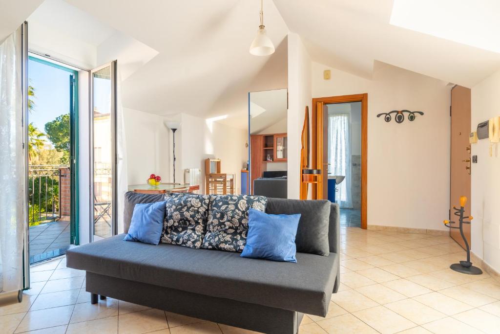 ein Wohnzimmer mit einem Sofa und einer Küche in der Unterkunft [5 min dal MARE] Luminoso Bilocale con Terrazza in Loano