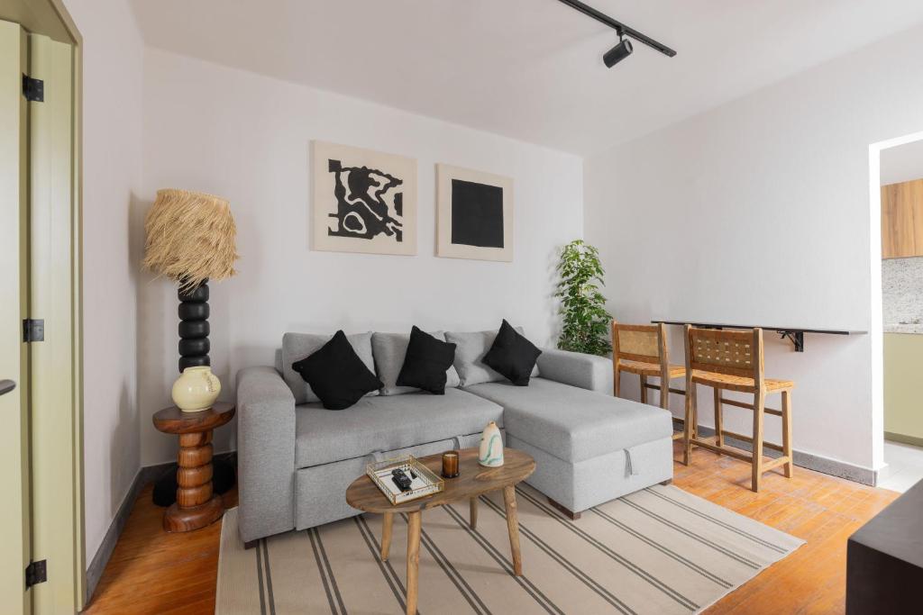 ein Wohnzimmer mit Couch und Tisch in der Unterkunft Baranda OCHO in Mexiko-Stadt