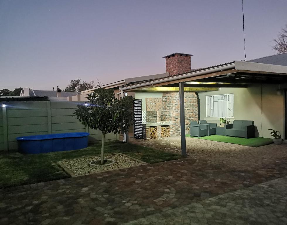 uma casa com um pátio com uma árvore no quintal em Lekaja em Oudtshoorn