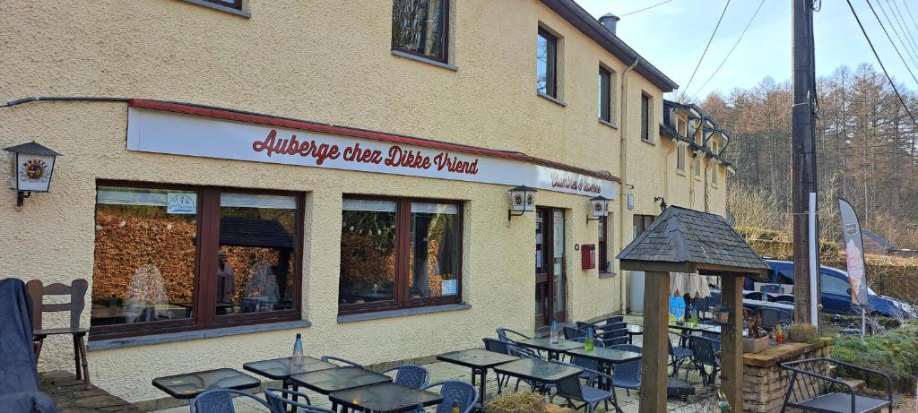 a restaurant with tables and chairs outside of a building at Dikke Vriend , herberg & taverne in Chiny