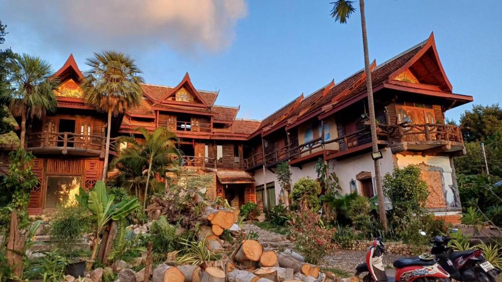 a house with a motorcycle parked in front of it at Orchid Home in Koh Tao