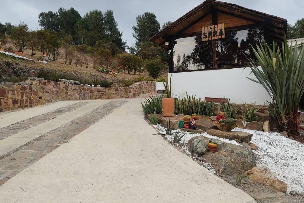 a road leading to a building with a sign on it at Finca La Sara in Ubaté