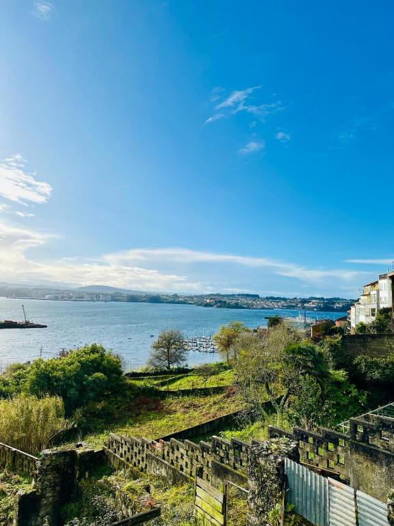 a view of a body of water with buildings and trees at Ventana a la Ría in Ferrol