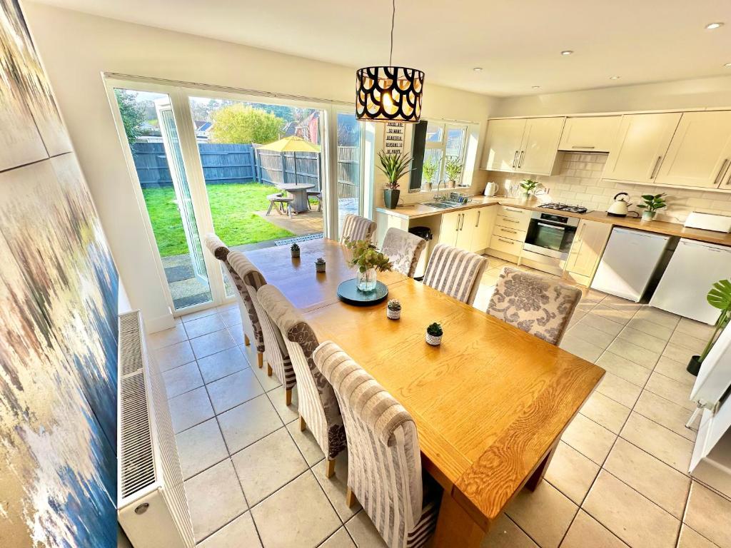 a kitchen and dining room with a wooden table and chairs at Large Four Bedroom - With Hot Tub and Parking - Sleeps 8 in Poole