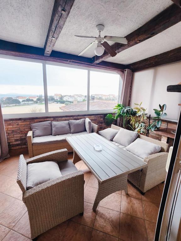 a living room with a table and couches and windows at Apartment Vanessa in Krk