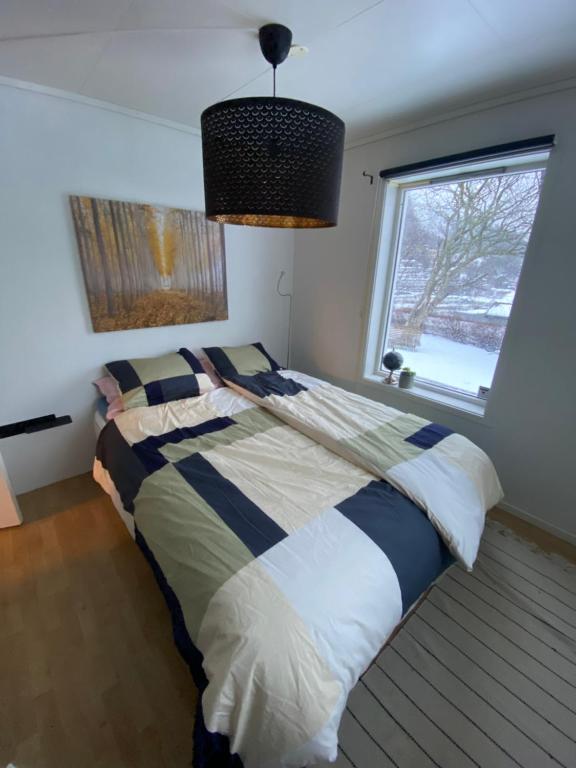 1 dormitorio con 1 cama grande y ventana en Leilighet i enebolig, en Bergen