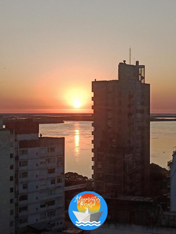 a sunset over a city with a building at DEPTO CON VISTA AL RIO!! UBICACION IDEAL!! PRECIO UNICOi! in Rosario