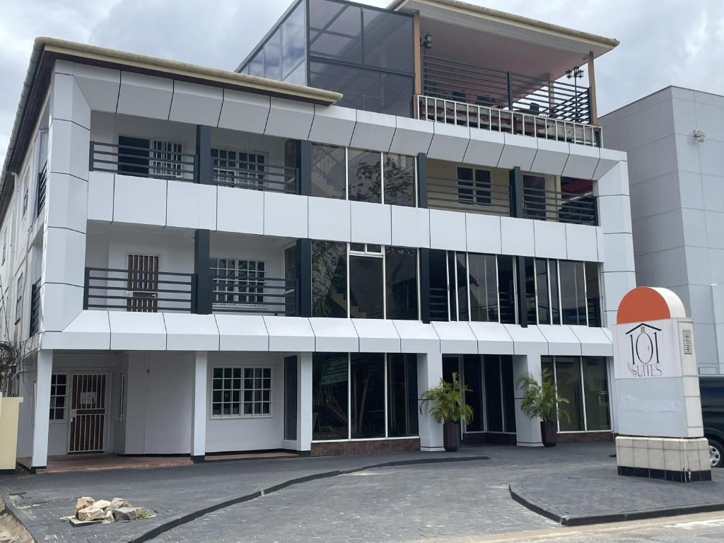 a large white building with a clock in front of it at 101 Suites in Paramaribo