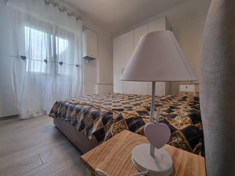 een slaapkamer met een bed en een lamp op een tafel bij Onda Azzurra in Imperia