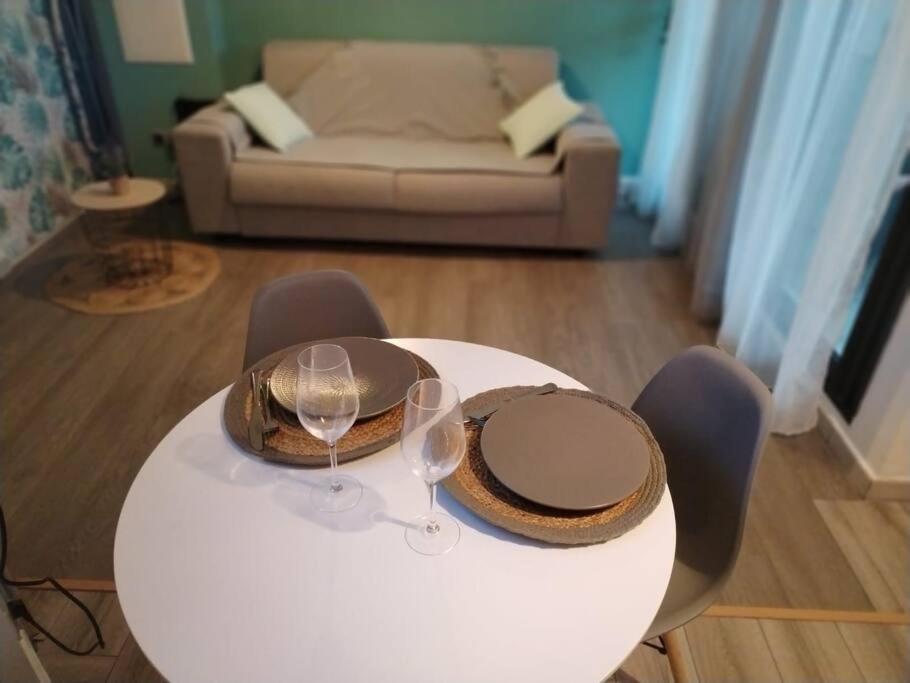 uma mesa com dois copos de vinho e um sofá em Studio le Zéphyr Ste Clotilde em Saint-Denis