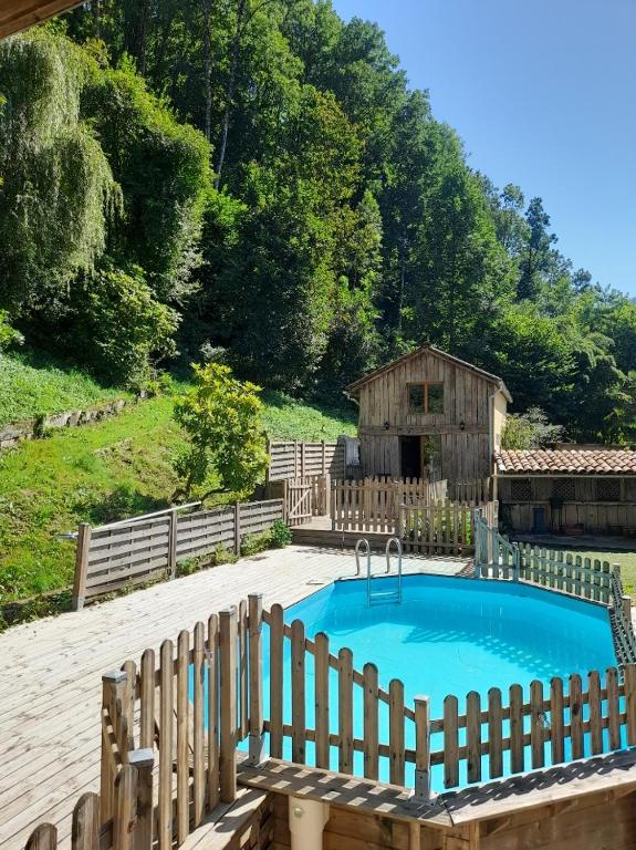 - une piscine dans une cour avec une clôture en bois dans l'établissement Gîte La Forêt du Domaine des Aguilès, à Nistos
