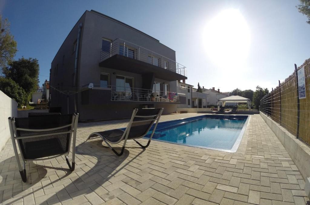 a house with a swimming pool in front of a house at House Barbara in Banjole