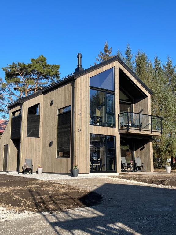 Egersund Overnatting في إيجرشوند: منزل خشبي كبير مع شرفة وزجاج