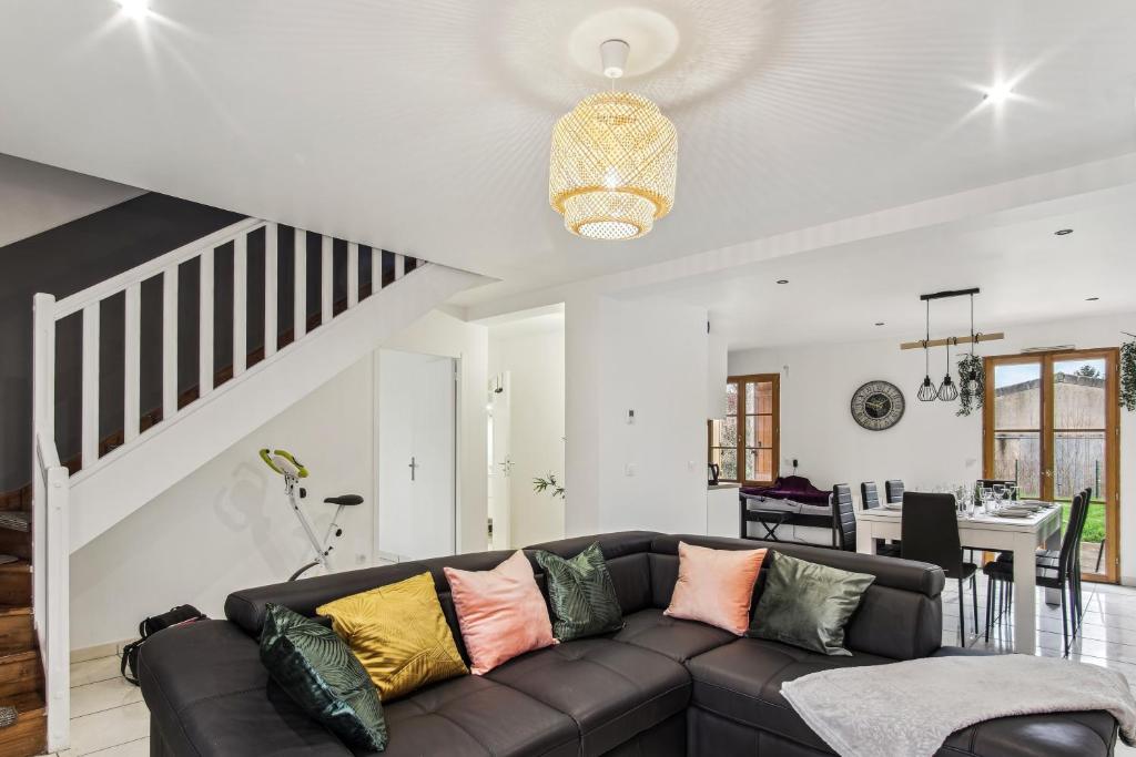 uma sala de estar com um sofá castanho com almofadas coloridas em Chic friendly and spacious house em Meaux