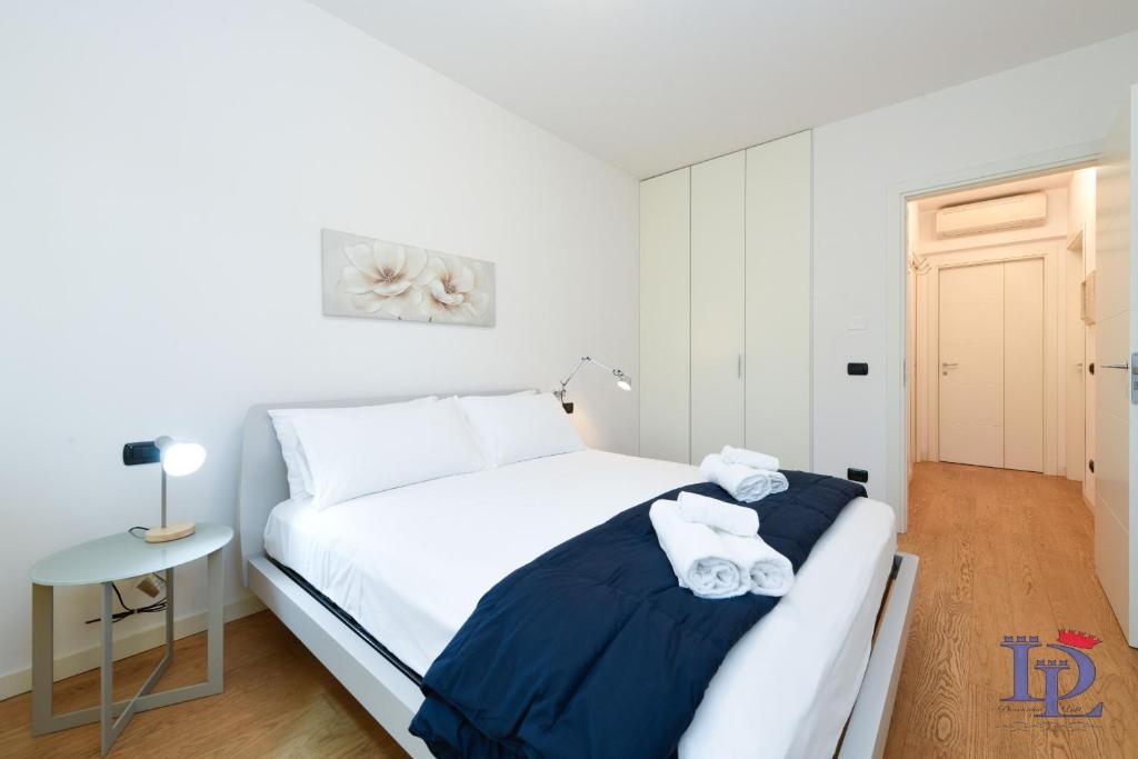 sypialnia z białym łóżkiem i stołem w obiekcie Desenzanoloft The Wind Rose w mieście Desenzano del Garda