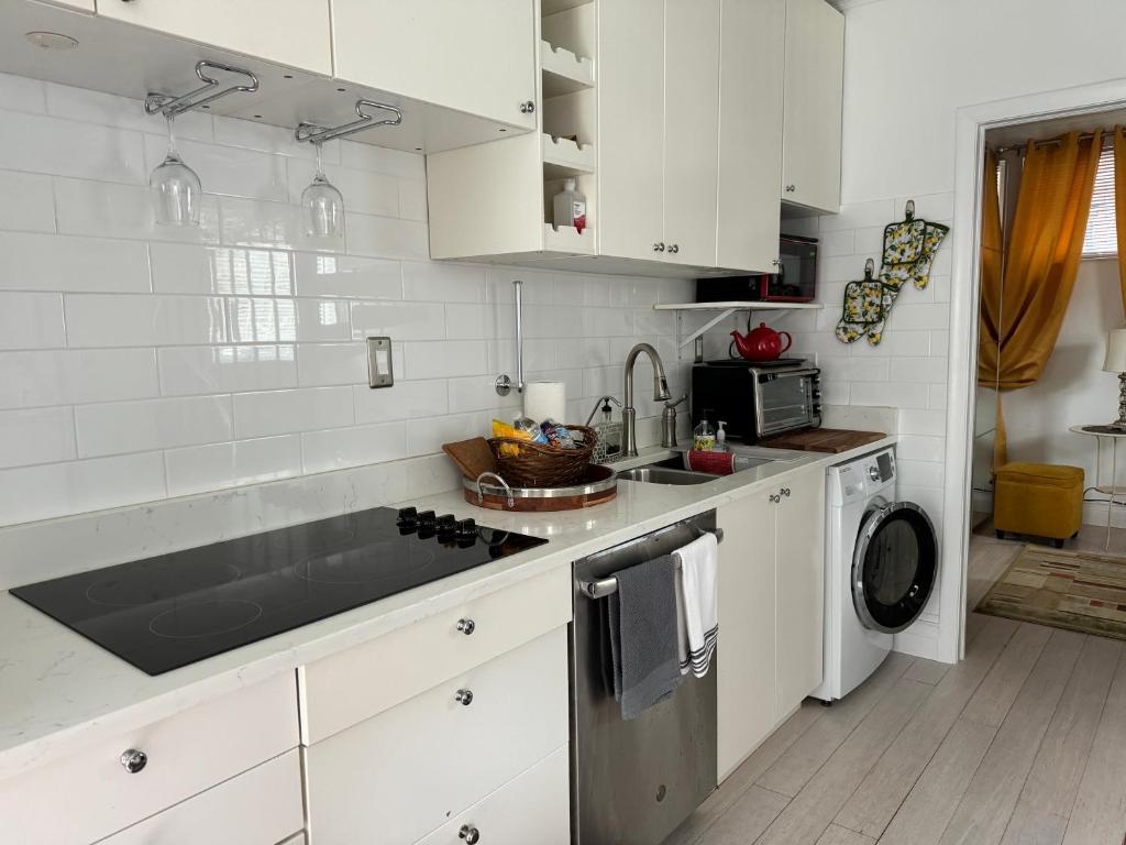 a white kitchen with a sink and a dishwasher at 2 mini bedrooms with water view 